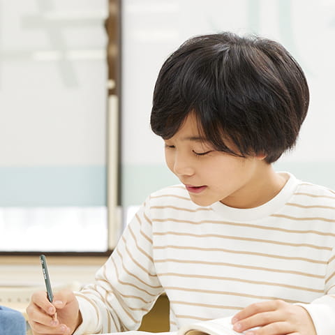 児童がノートに向かってテストに取り組んでいる様子
