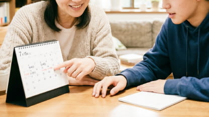 カレンダーを見ながら日程を確認する親子